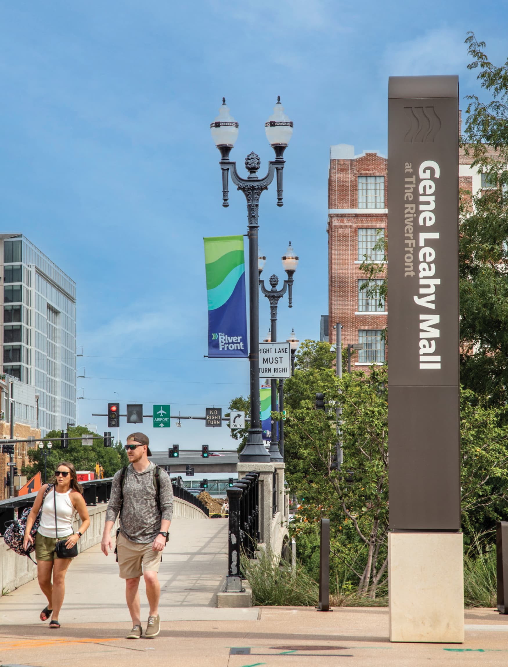 Image of two people visiting the Omaha RiverFront. Signage for Gene Leahy Mall at the Omaha RiverFront is designed by RSM Design.