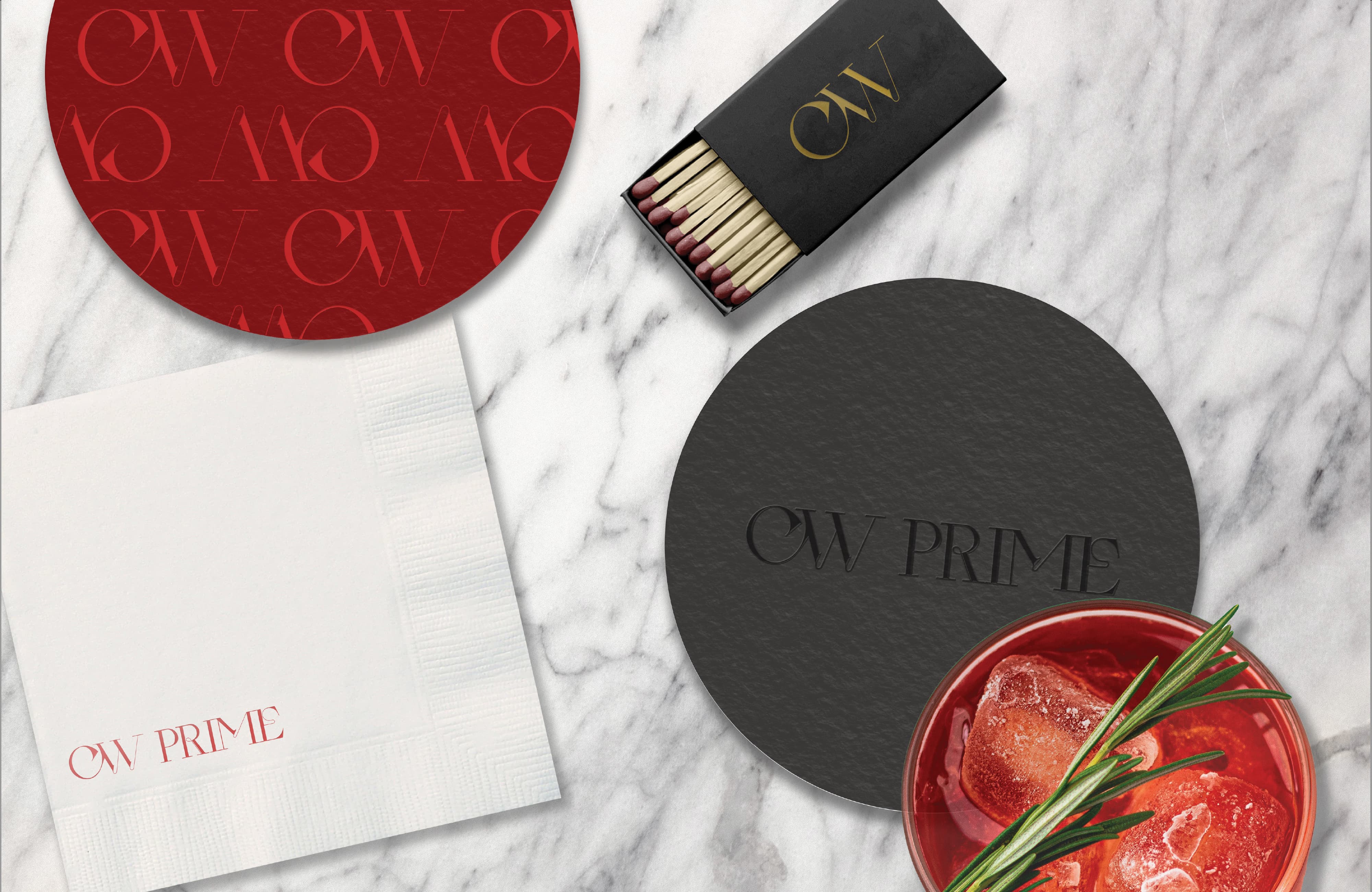 CW Prime branded print collateral suite including branded coasters, cocktail napkins, and matchbox packaging with logo monogram pattern on a marble surface — RSM Design branding and visual identity, print and digital collateral, and specialty graphics for hospitality and food and beverage destinations.
