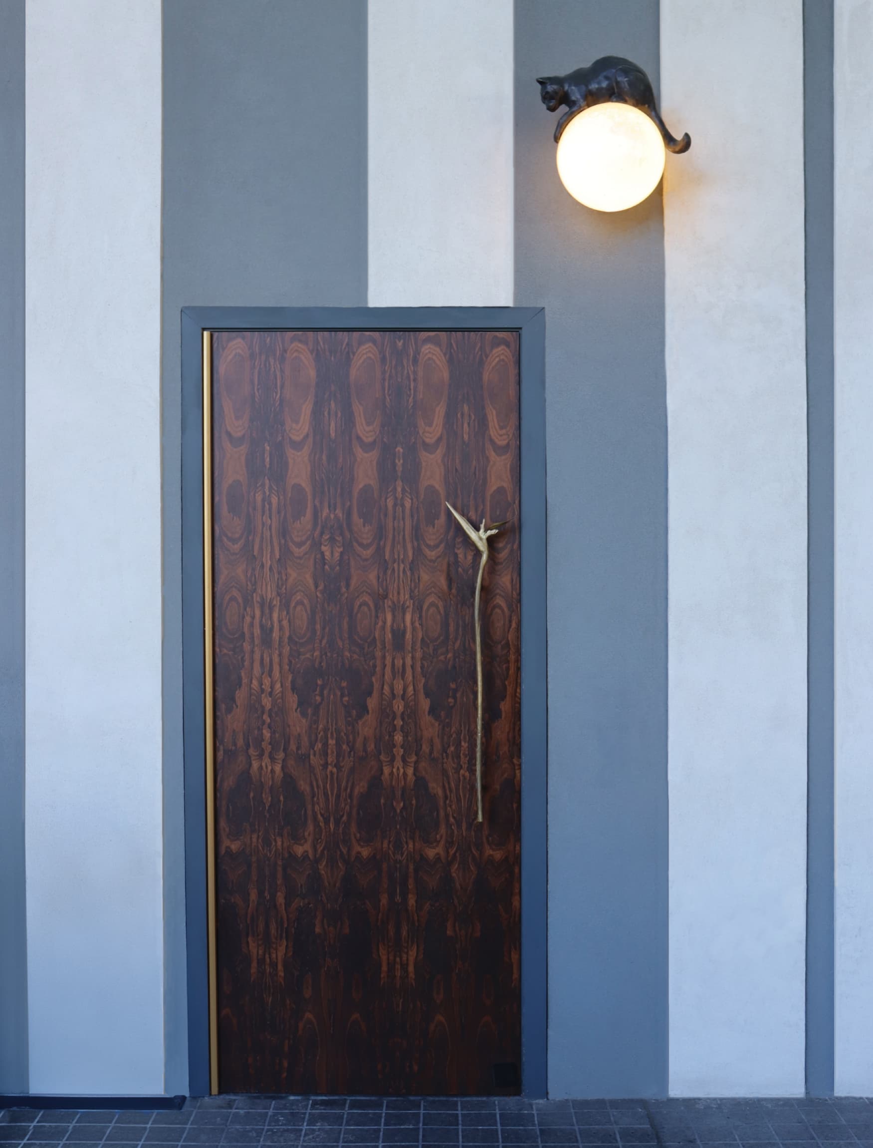 Image of the secret doorway to Babou's, a speakeasy within the Hotel Swexan. Custom light fixture designed by RSM Design. 
