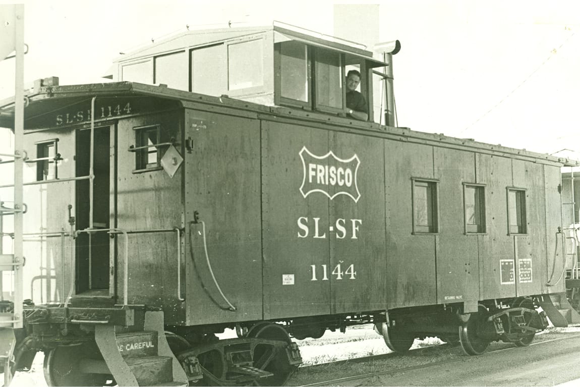 Black-and-white archival photo of Frisco Railroad caboose No. 1144, marked "SL-SF," with a crew member visible in the cupola above.