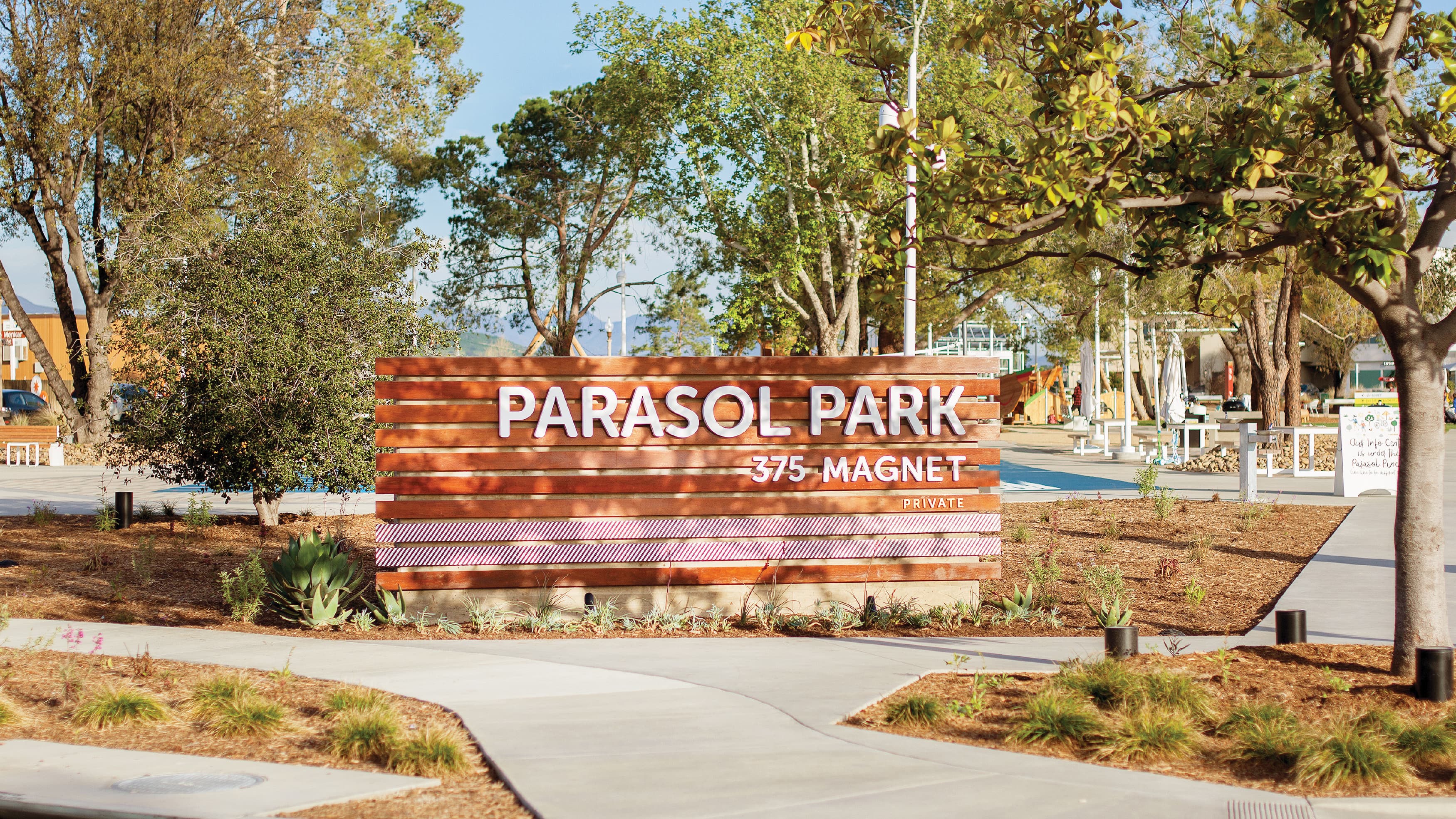 Parasol Park horizontal, wooden-slat sign identity integrated into the landscape