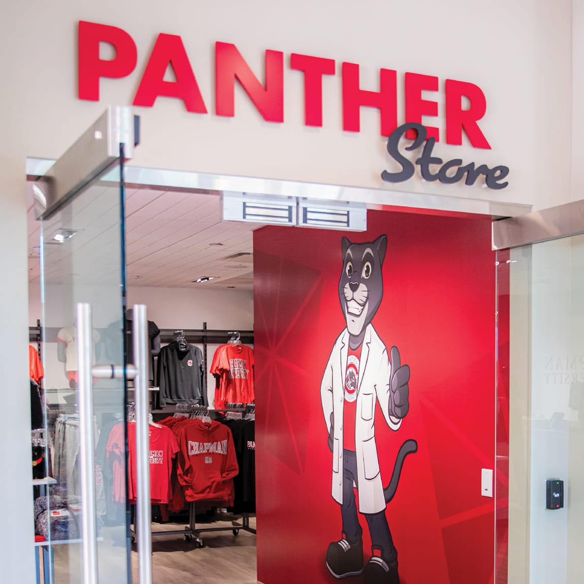 RSM Design Chapman University Rinker Campus Center Irvine — Panther Store retail entrance with dimensional red lettering, Chapman University mascot wall graphic, and campus merchandise visible inside