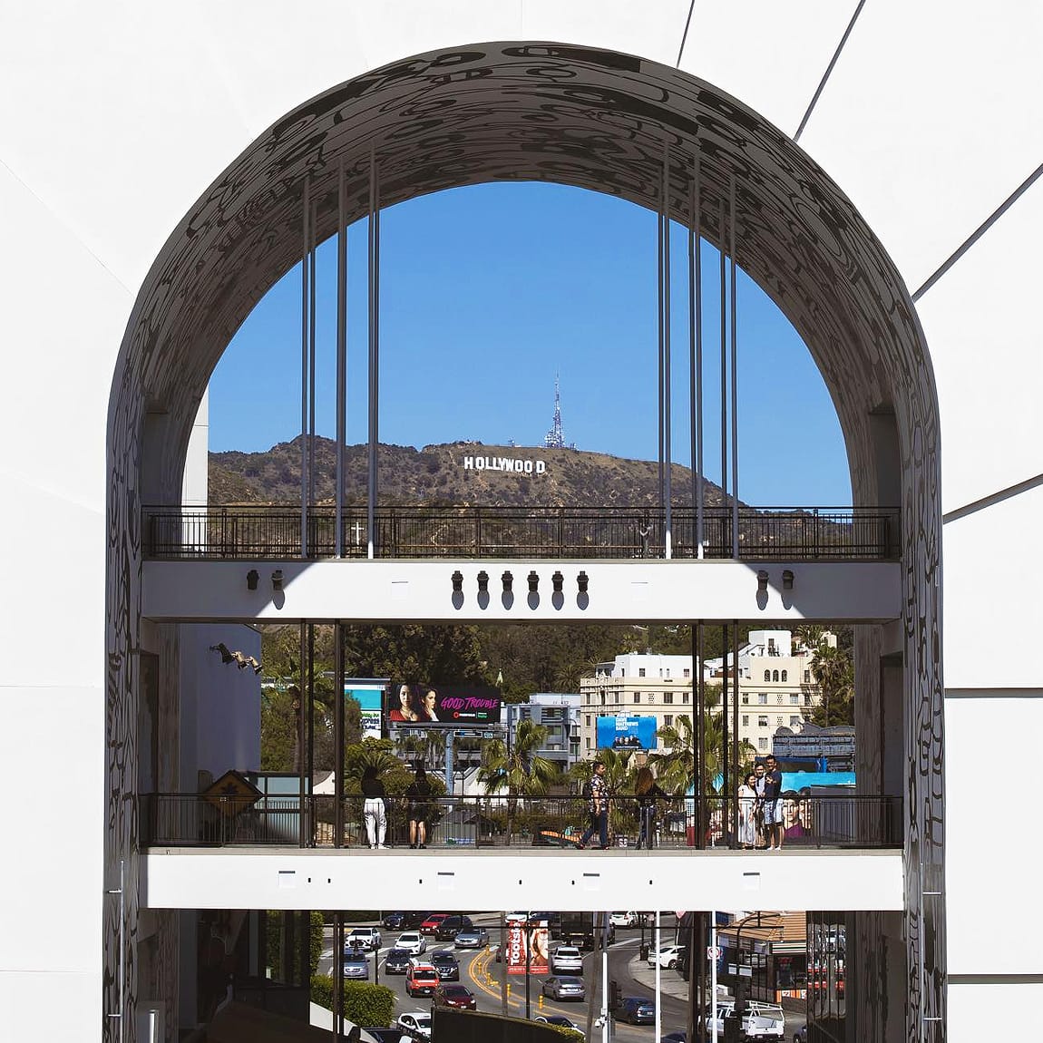 Iconic view of the Hollywood Sign framed through the decorative arch of Ovation Hollywood shopping center on Hollywood Boulevard, Los Angeles