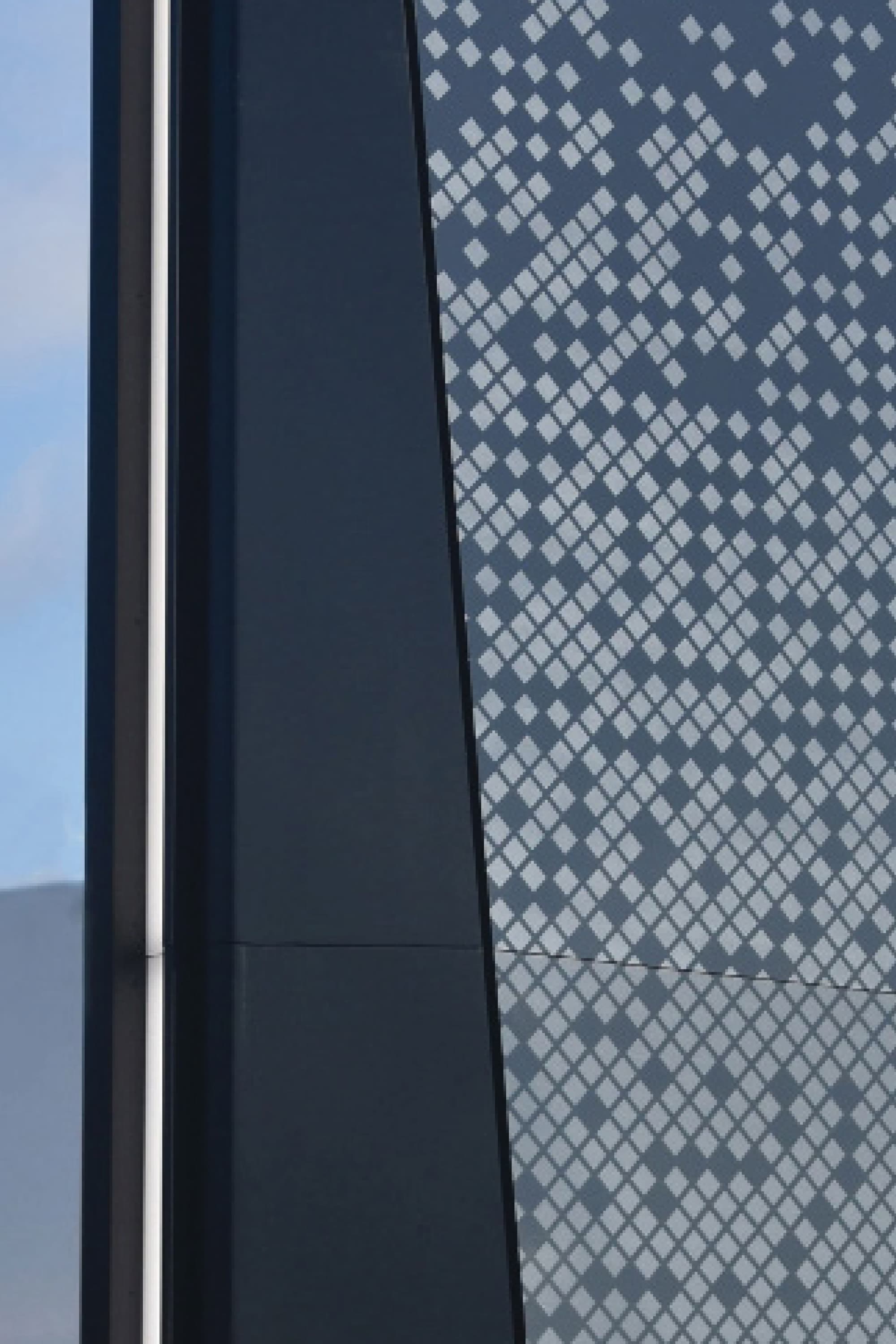 Close-up detail of patterned monument signage at a retail destination, showcasing environmental graphic design, material expression, and branded wayfinding elements that support placemaking in mixed-use retail and commercial environments.