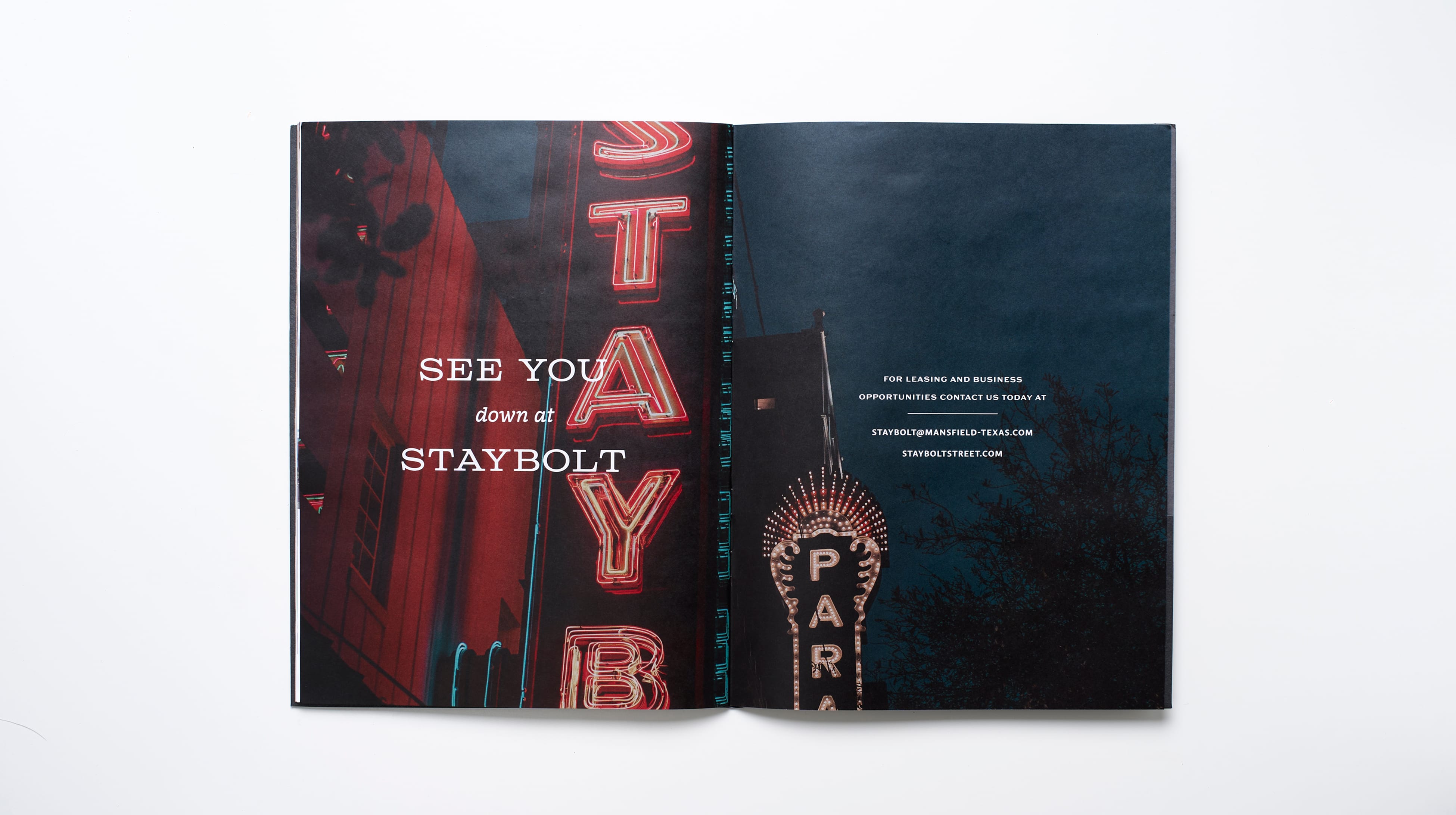 Open leasing brochure spread with a close-up of red neon signage reading STAYBOLT on a brick building at dusk, paired with a night sky photo of an illuminated theater marquee and leasing contact information, Staybolt Street, Mansfield, Texas, brand identity and leasing collateral design by RSM Design