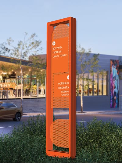 RSM Design vehicular wayfinding pylon sign for HUB RTP — bold orange dimensional directional sign with perforated panel details directing visitors to Boxyard, Frontier Office Tower, Horseshoe Residential, and Parking Garage at Research Triangle Park, Durham NC