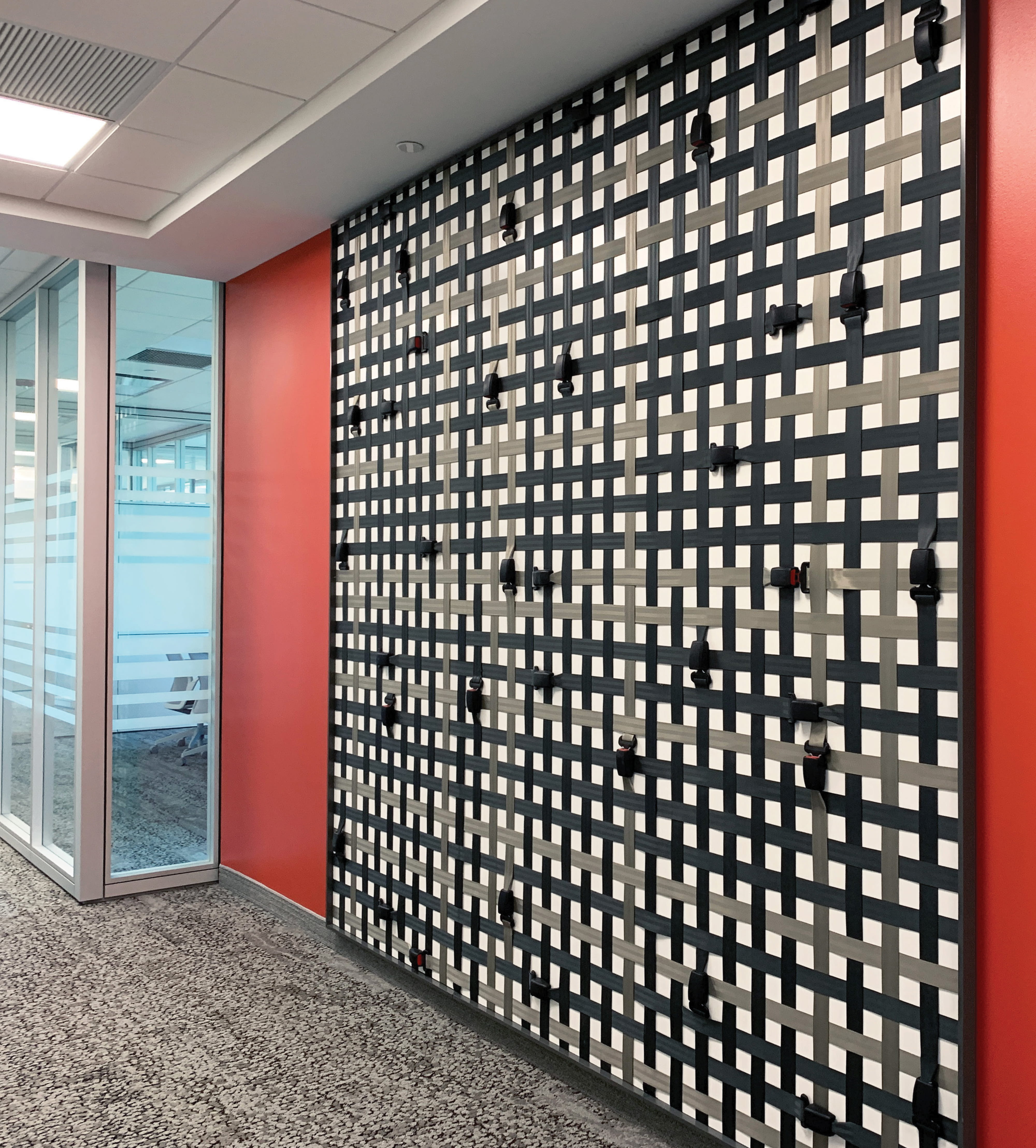 Workplace environmental graphic design feature wall using layered materials and branded detailing to create an immersive interior experience, reflecting experiential design, placemaking, and brand integration within a corporate office environment.