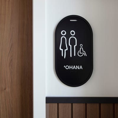 "Ohana" ADA restroom sign with pictograms and braille on wood paneled wall at Wai Kai, Ewa Beach, Oahu, ADA signage by RSM Design.