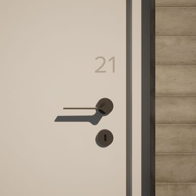 Close-up rendering of a Bloc House unit door, showing a minimalist white door with the number "21" in subtle gray type, fitted with a dark metal lever handle and keyhole, set against a concrete tile corridor wall.