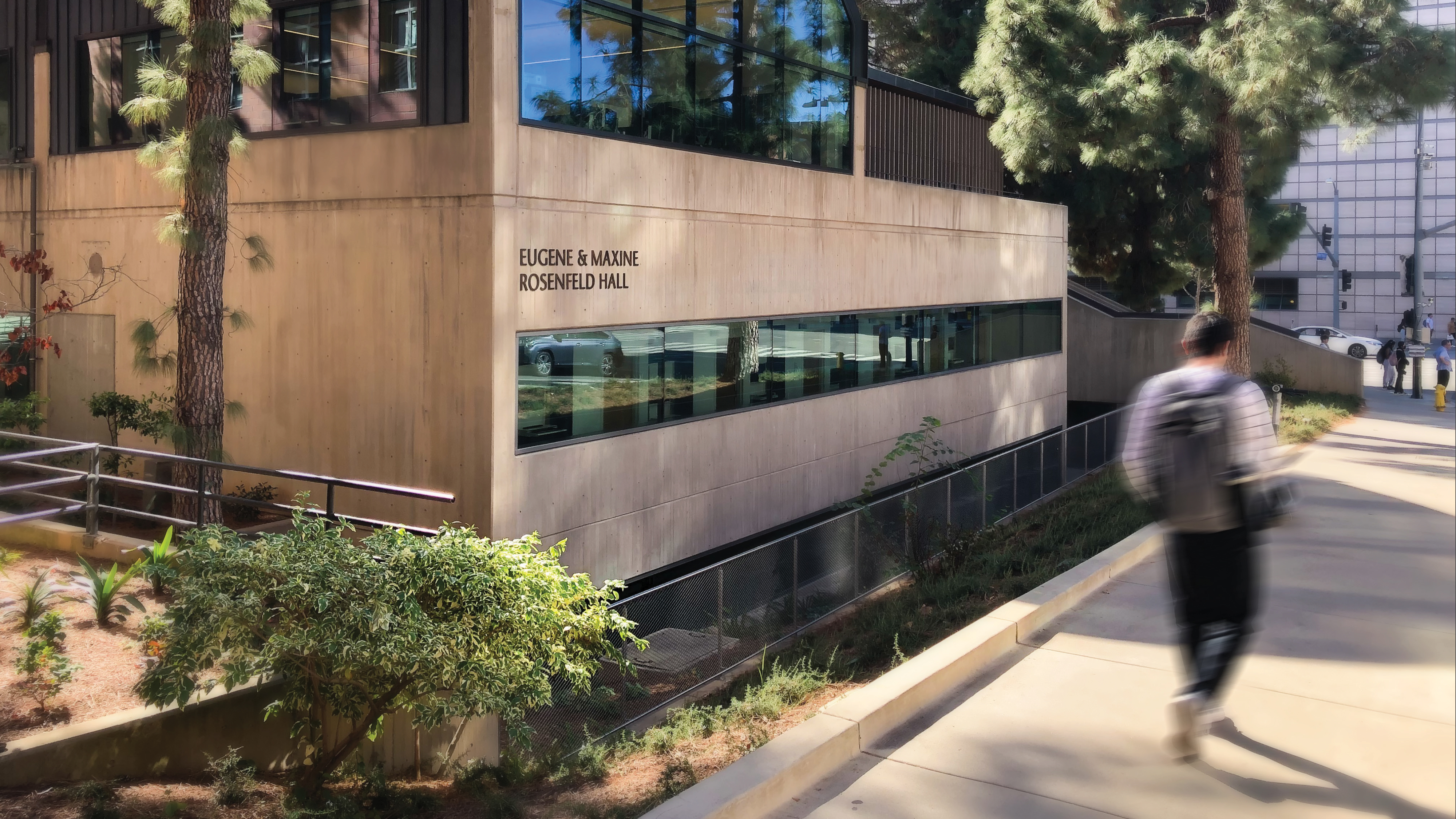 Environmental graphic design and architectural signage at Eugene & Maxine Rosenfeld Hall on a university campus, featuring integrated building identification and wayfinding that connects people to place through experiential design and placemaking.