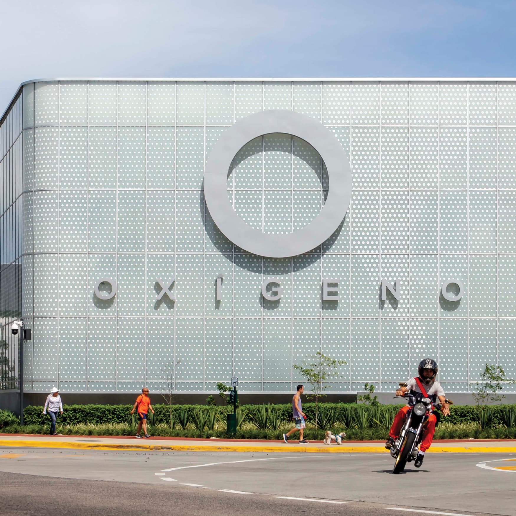 Oxigeno Retail building facade signage in the background as motorcycle rides in front