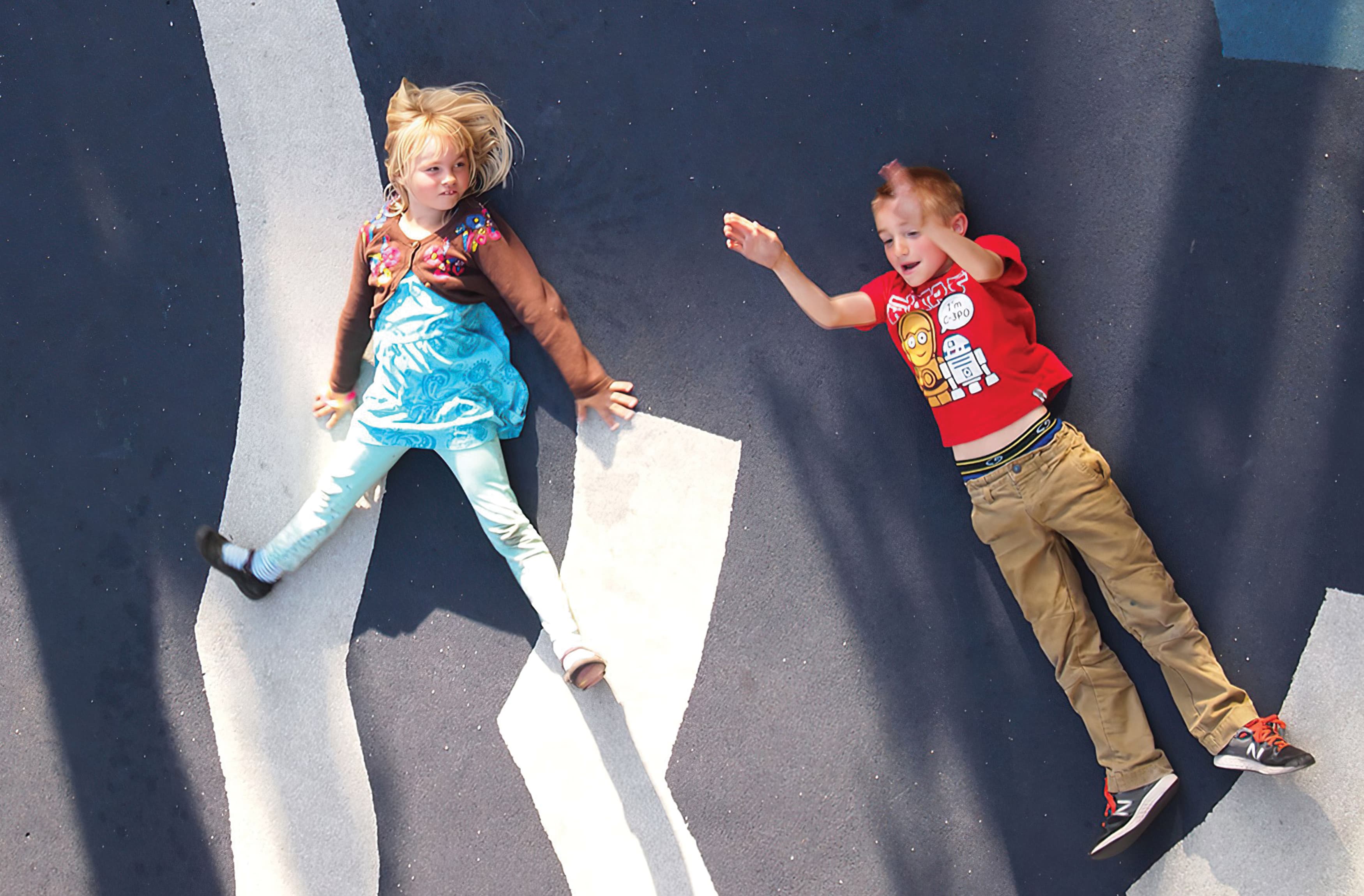 Children playing in an area with painted pavement graphics.