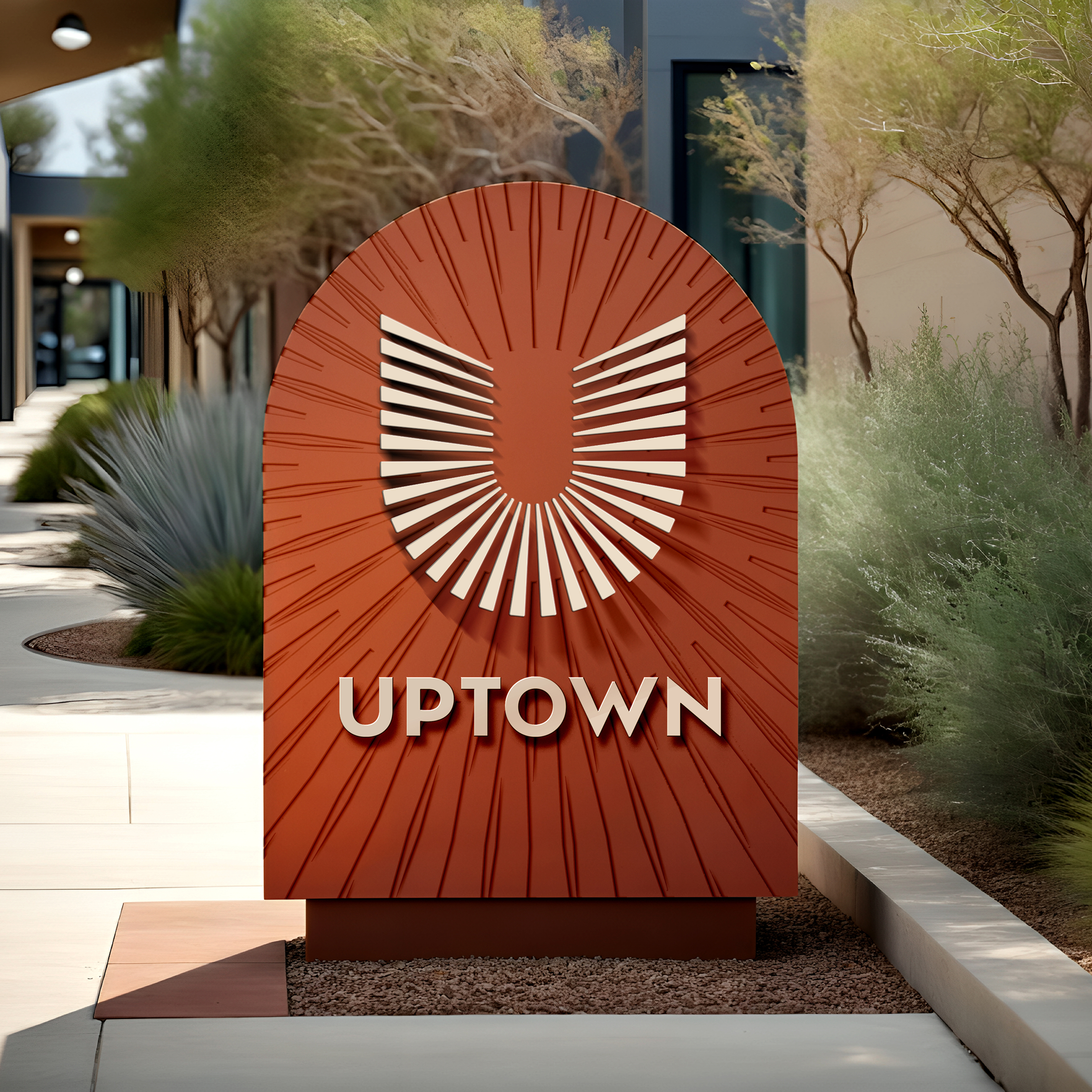 Uptown Tucson arched monument sign with dimensional U emblem along a desert walkway, environmental branding by RSM Design