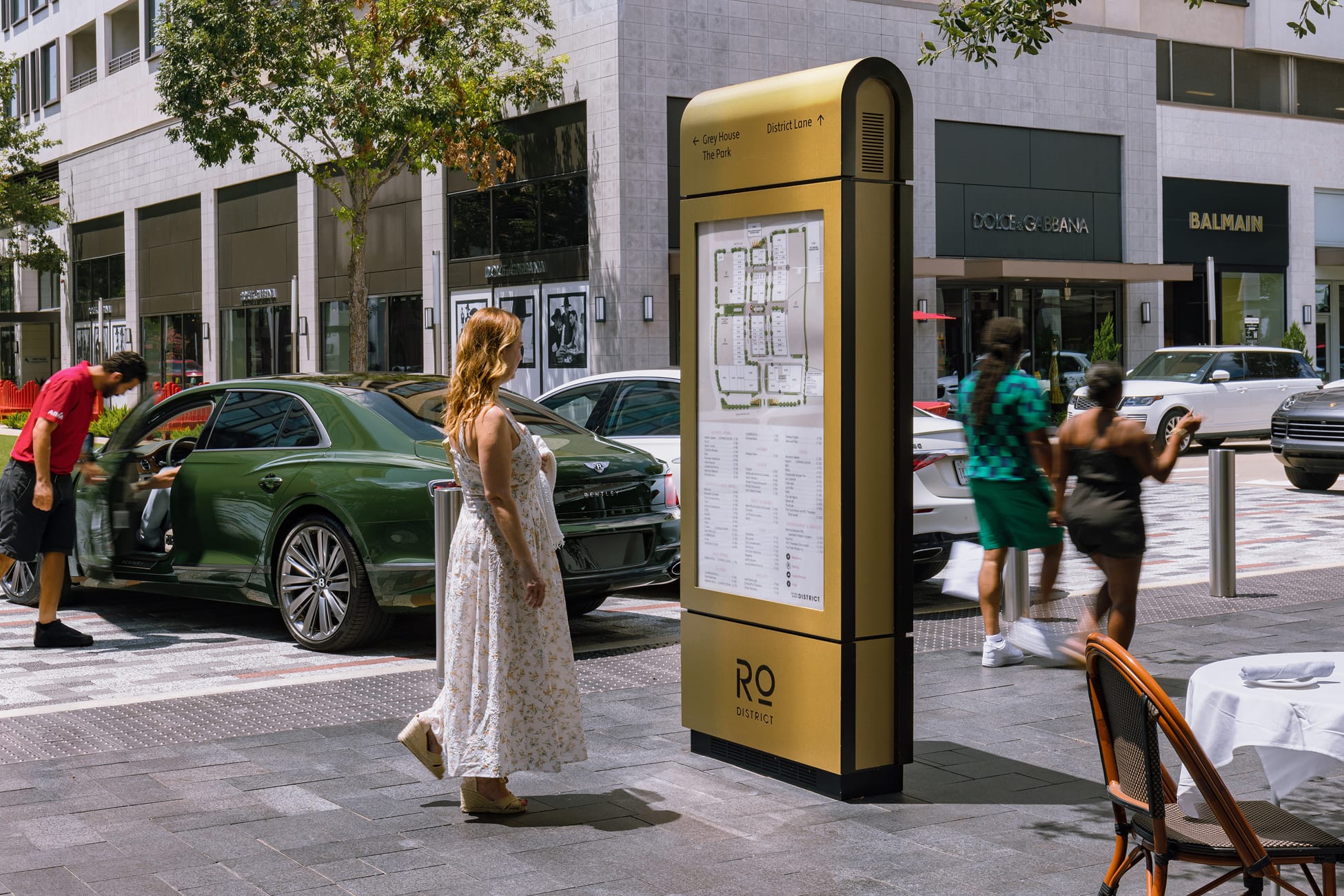 River Oaks District Houston gold directory kiosk with property map near luxury retail storefronts, wayfinding design by RSM Design