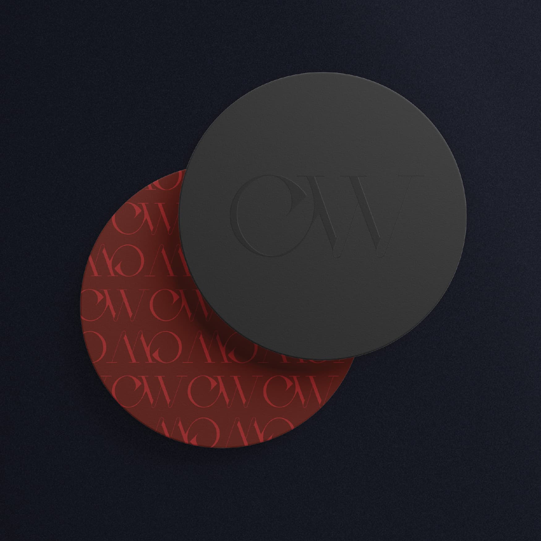 Image of the custom coasters for CW Prime at the St. Regis Longboat Key Resort. One is designed with the brand patterning with red shades, and the other is tone on tone black with embossed, glossed logo mark. 