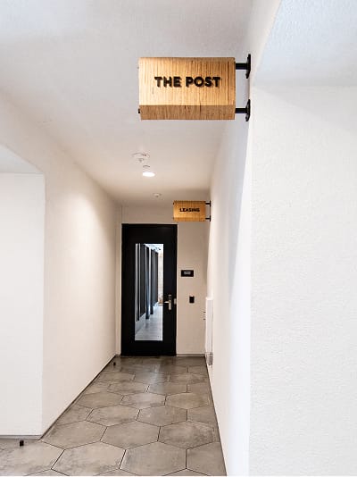Persea residential community wood blade signage for The Post and Leasing along hallway, wayfinding design by RSM Design
