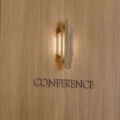 Dimensional "Conference" sign beneath a sconce light fixture on a wood-paneled wall at Maple Terrace - environmental graphic design by RSM Design