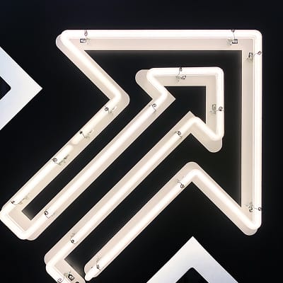 Illuminated arrow graphic at Fifth + Broadway, using bold form and light to reinforce directional cues and enhance the overall wayfinding experience.