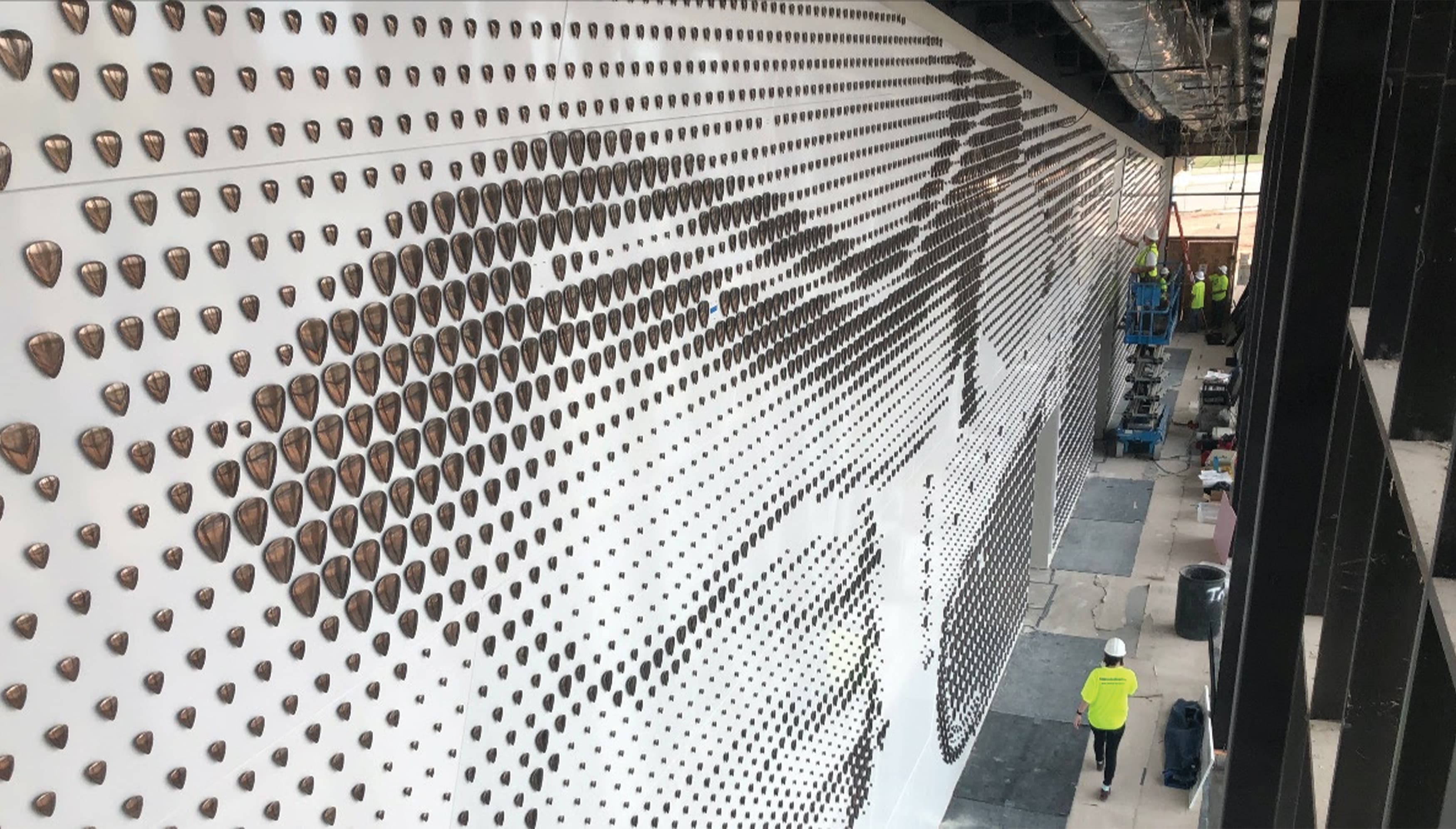 Detail of guitar pick specialty graphics being installed on donor wall of Buddy Holly Hall in Dallas, TX