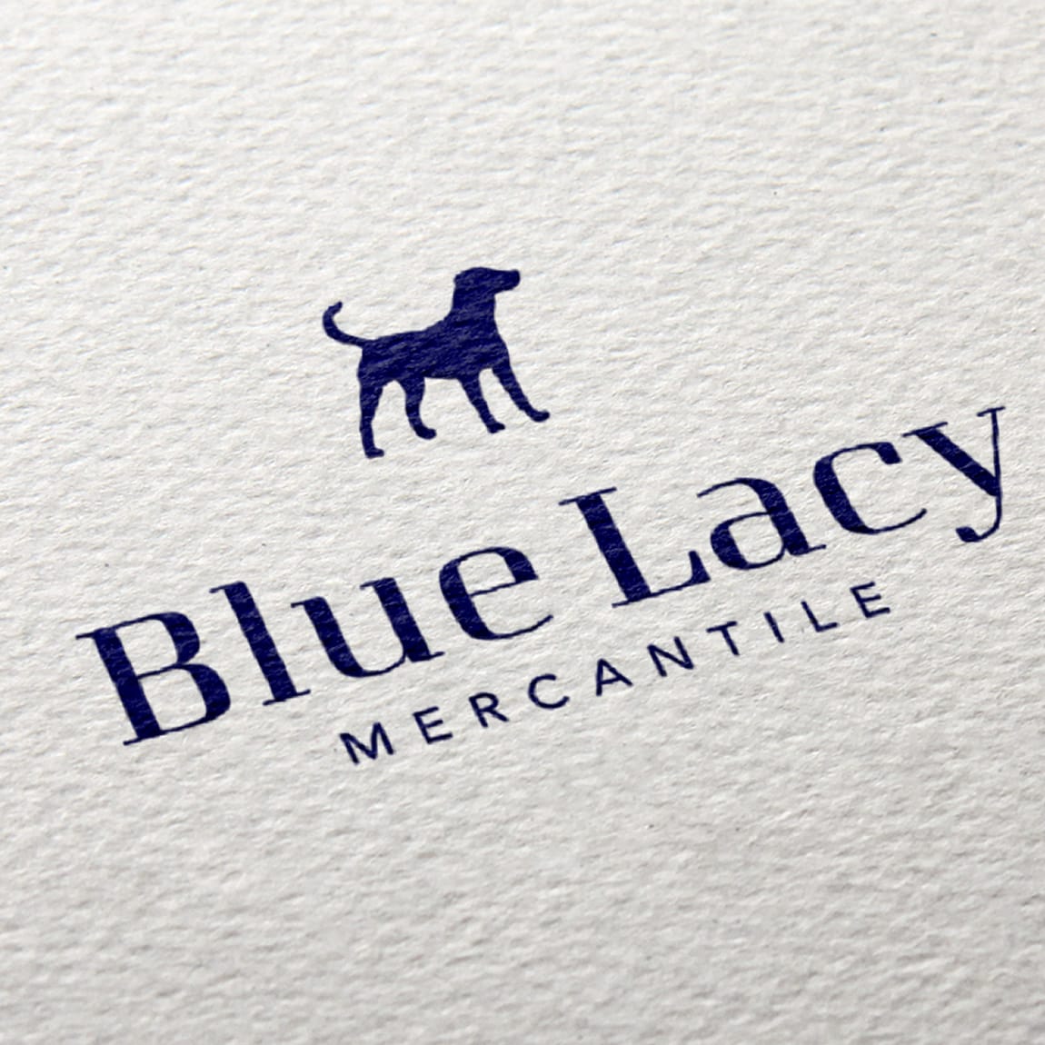 Blue Lacy Mercantile brand logo featuring navy blue dog silhouette and elegant serif typography printed on textured white paper, retail shop branding at Omni PGA Frisco