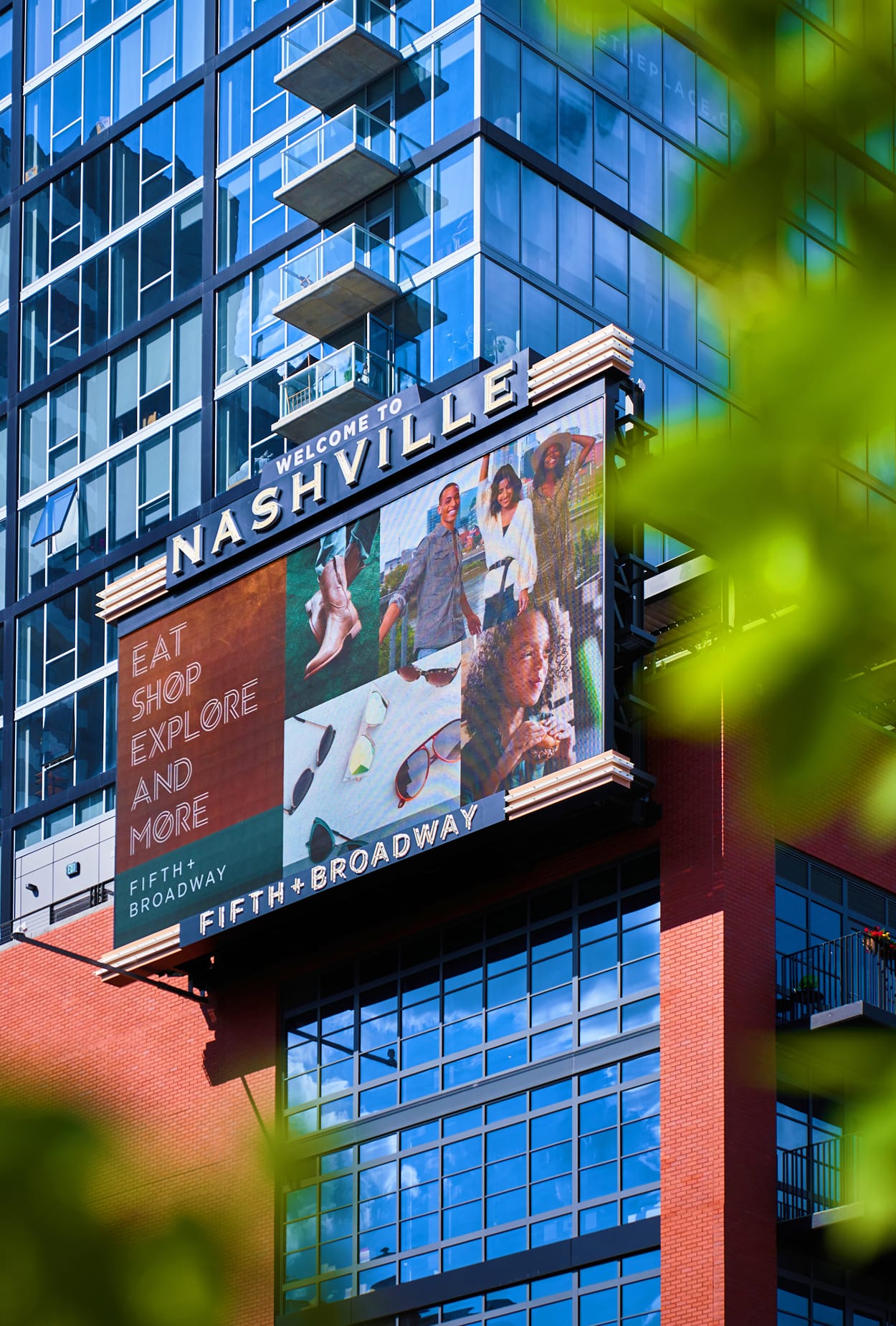 A large-scale digital display anchors the building facade, broadcasting district messaging and activity while reinforcing a bold, contemporary identity within the urban skyline.