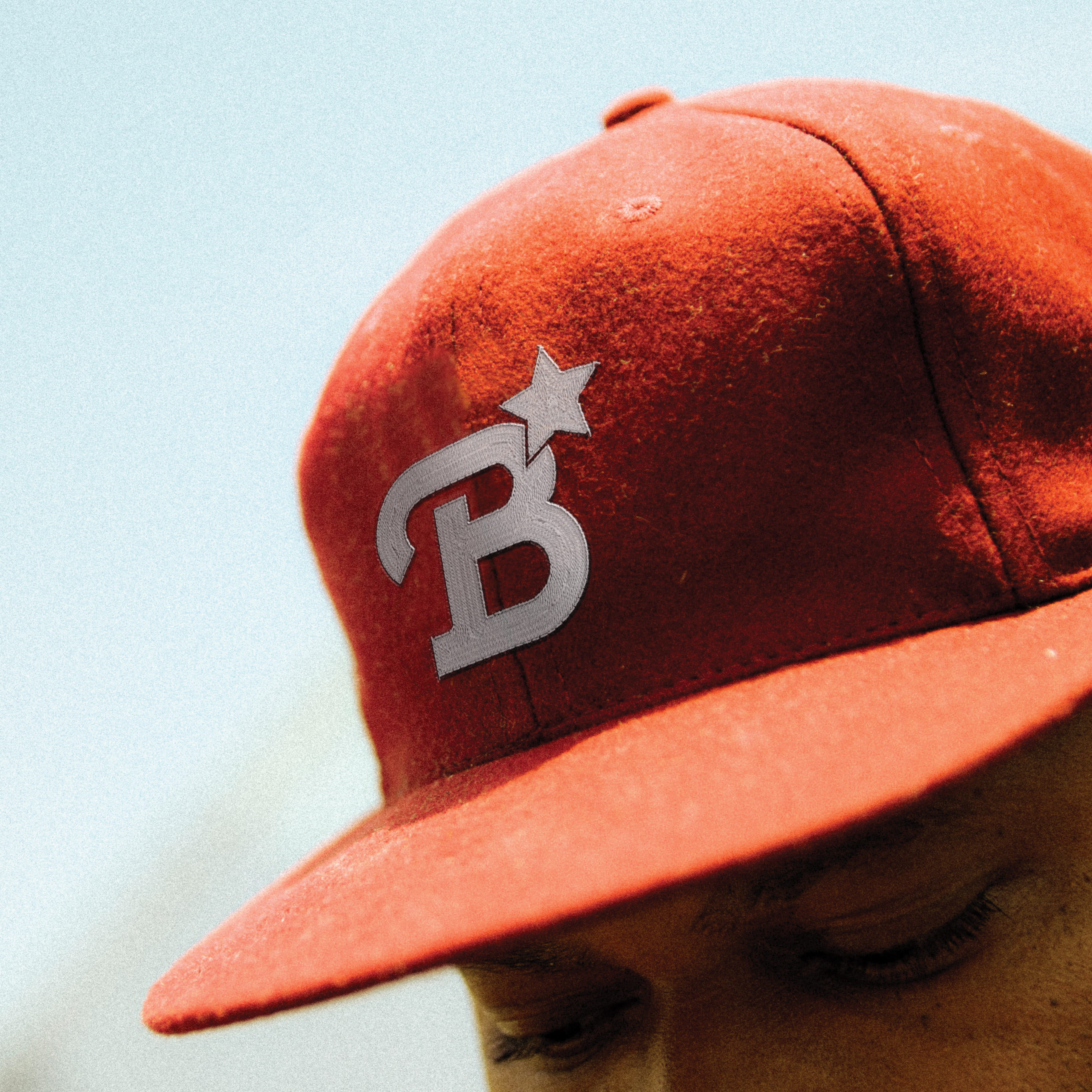 Red cap featuring The Bend HTX logo and star mark, highlighting brand identity design, branded merchandise, and experiential branding that support placemaking for a mixed-use retail, dining, and entertainment destination.