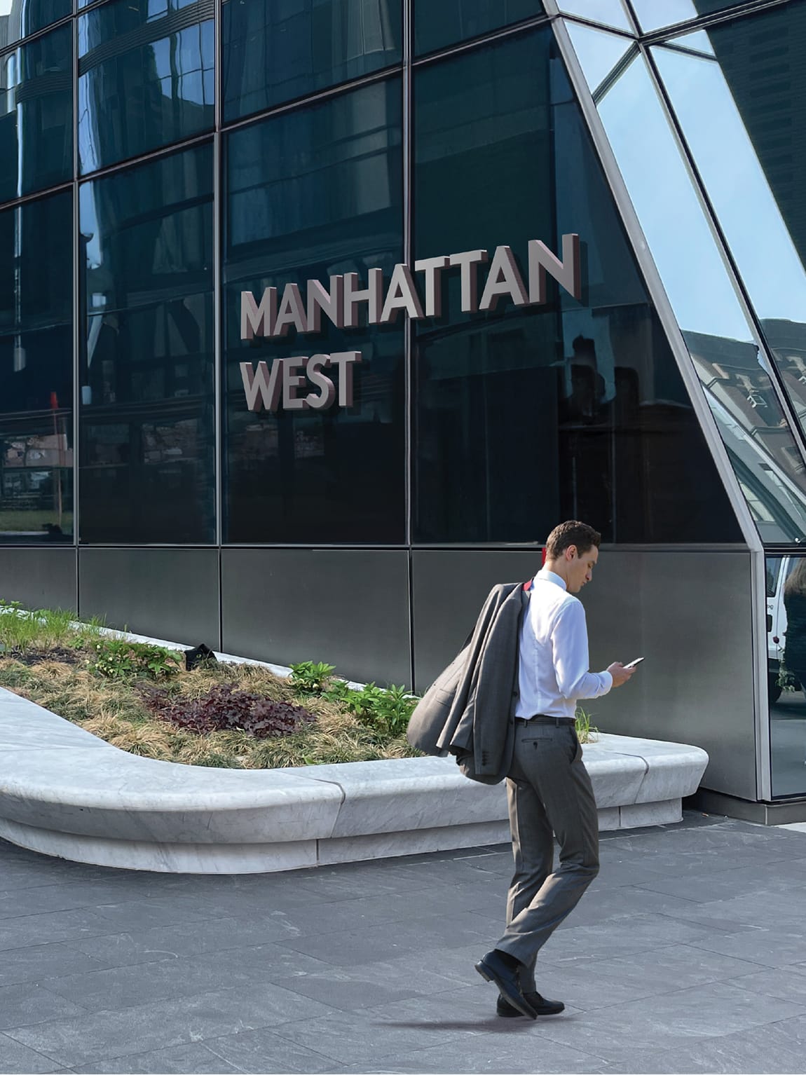 "Manhattan West" building sign on a glass tower facade above a landscaped planter - environmental graphic design by RSM Design