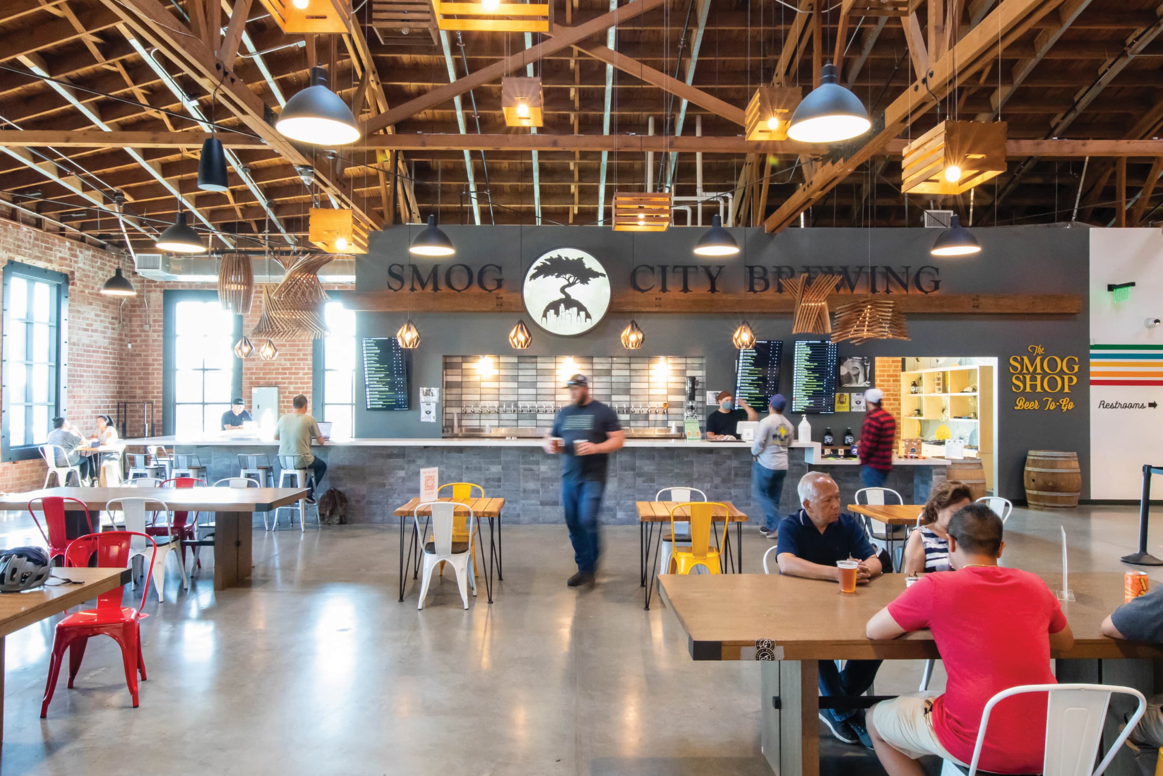 Interior of Smog City Brewing taproom featuring environmental graphic design, branded signage, and experiential wayfinding, integrating brand identity, placemaking, and user experience within a retail, hospitality, and mixed-use destination by RSM Design