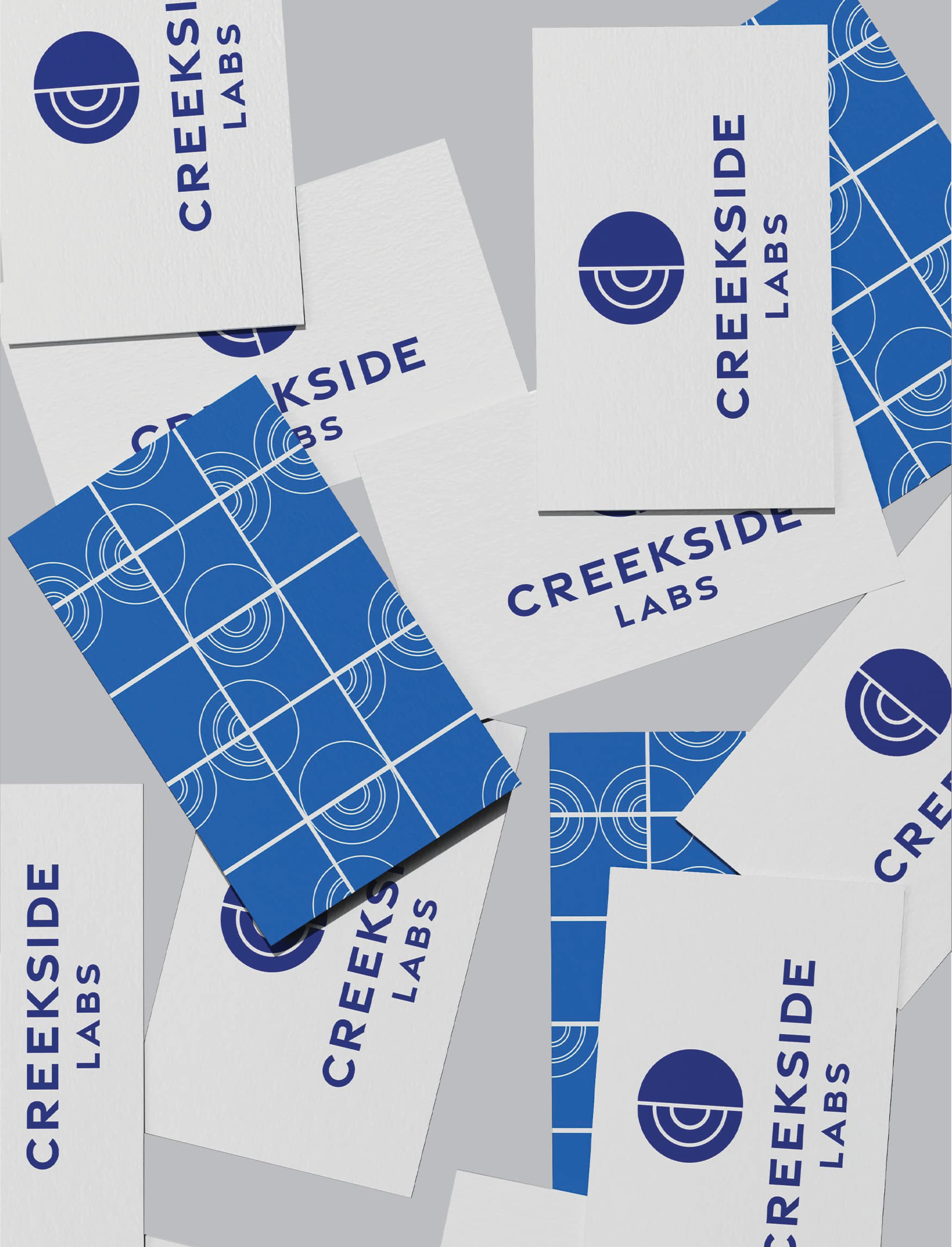 Creekside Labs branded stationery and business cards featuring a cohesive visual identity system, illustrating brand strategy, graphic design, and environmental graphic design services for workplace and life science campus environments.