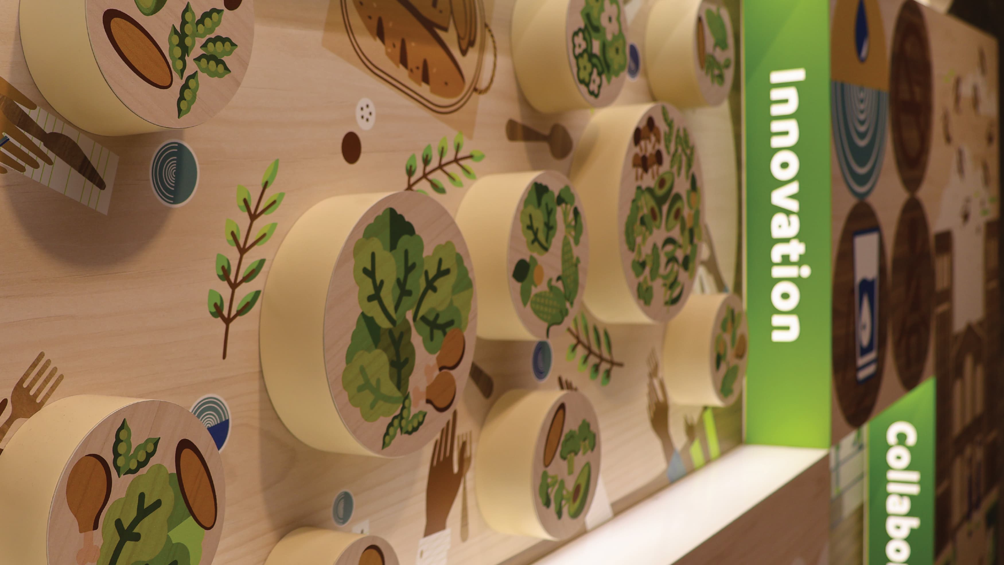 Detail image of the wall the UCLA Fielding School of Public Health. Wooden blocks with illustrations and illuminated text make up the wall. 
