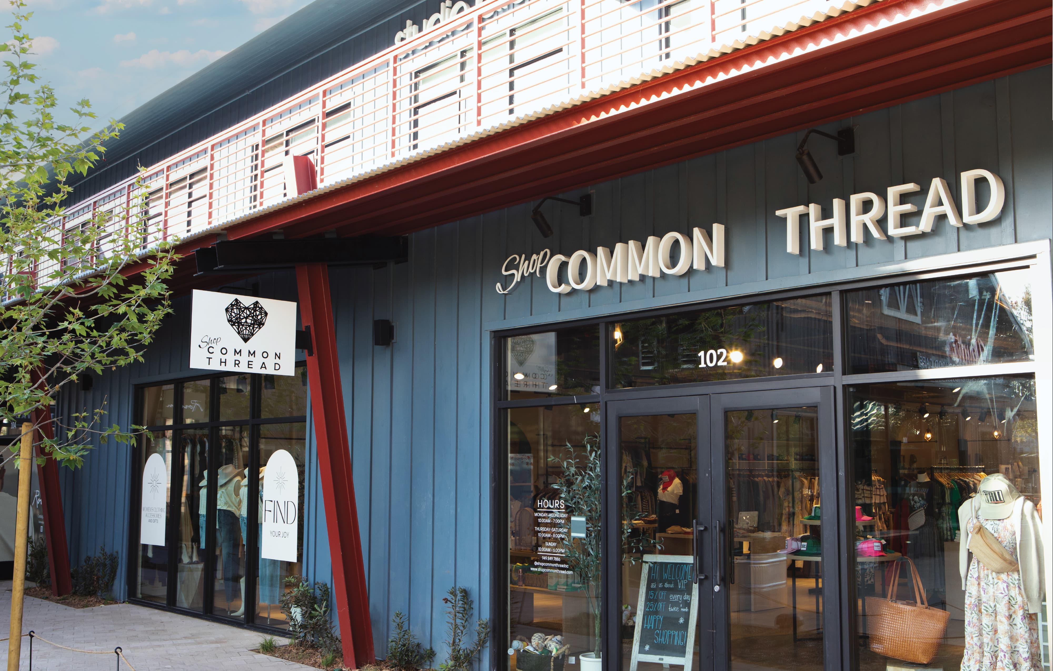 RSM Design storefront signage and environmental graphic design for Shop Common Thread at River Street Marketplace, featuring dimensional channel letters, a projecting logo blade sign, and window graphics integrated into a mixed-use retail facade, demonstrating a cohesive master sign program and branded environment that unifies visual identity with architecture for a retail and streetscape market.