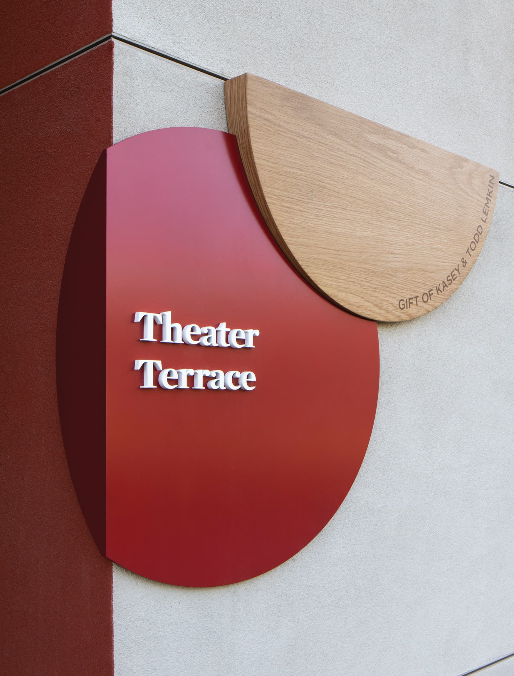 Theatre Terrace donor signage for Brentwood School by RSM Design. Natural warm wood with bold red wrap around wayfinding signage. 