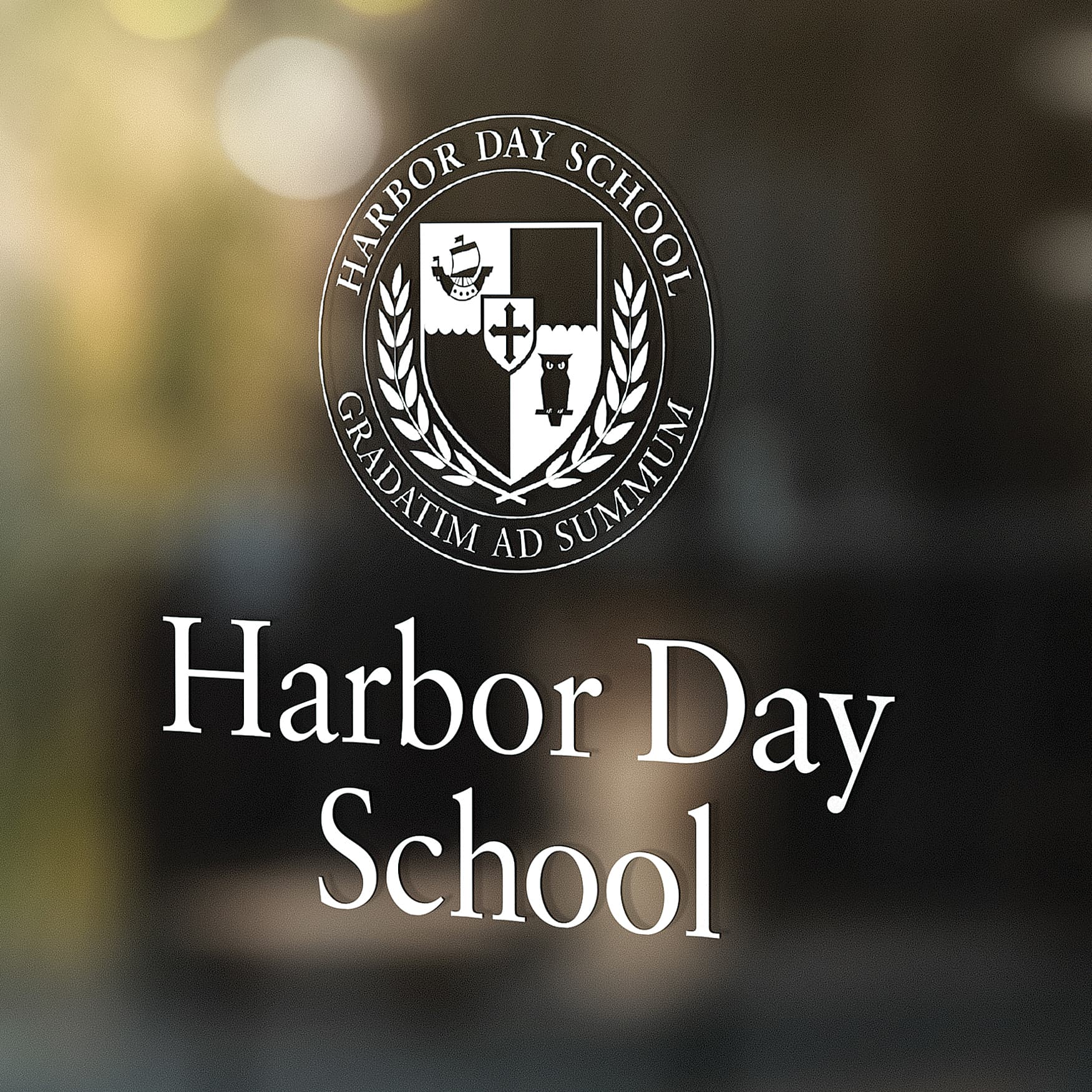 Harbor Day School logo printed on a glass reflective window.