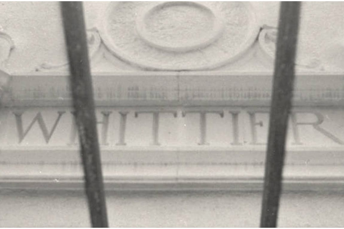 Historic black-and-white architectural detail of “Whittier” lettering on a classical building façade, reflecting the city’s heritage and typographic inspiration for the brand identity.
