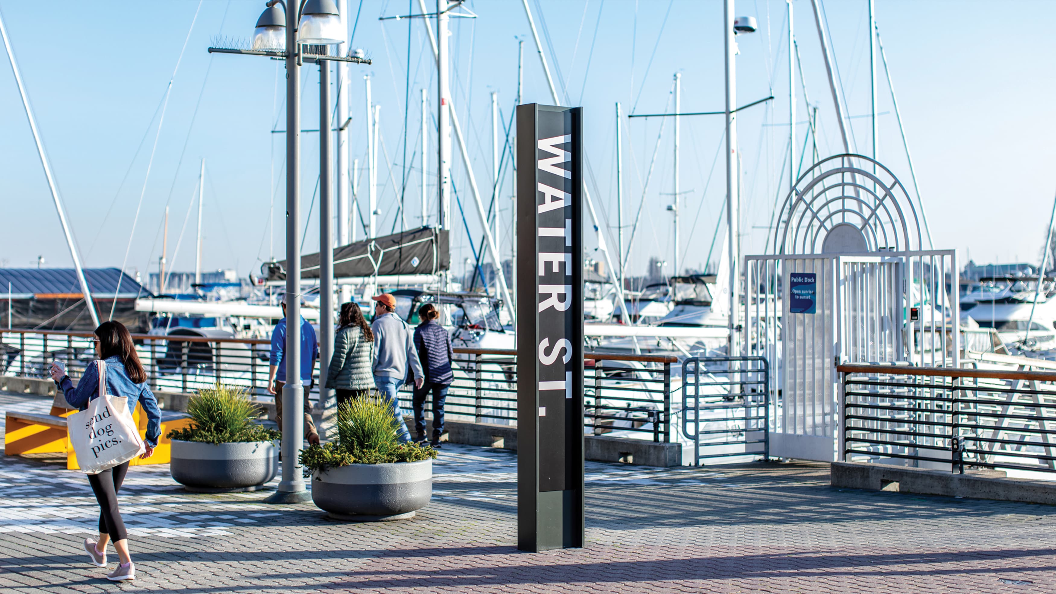 Oakland's historic Water Street at Jack London Square signage and pedestrians walking