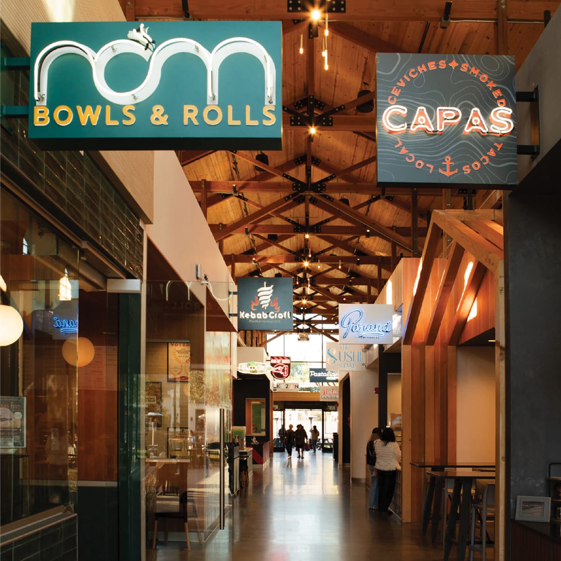 Food hall corridor with neon vendor blade signage, environmental graphic design by RSM Design