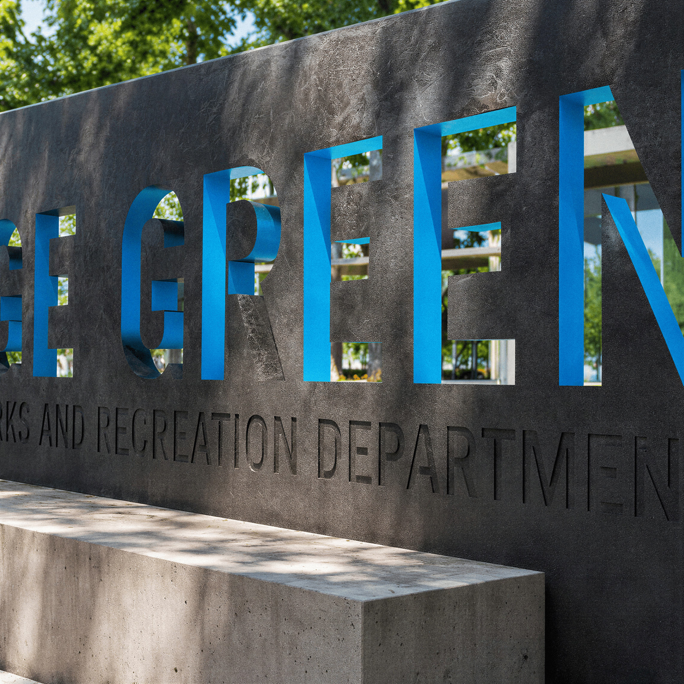 Close-up angled view of a dark concrete monument wall with cutout letters spelling '...ge Green' backlit in blue, above engraved text reading '...rks and Recreation Department,' with a concrete bench in front.
