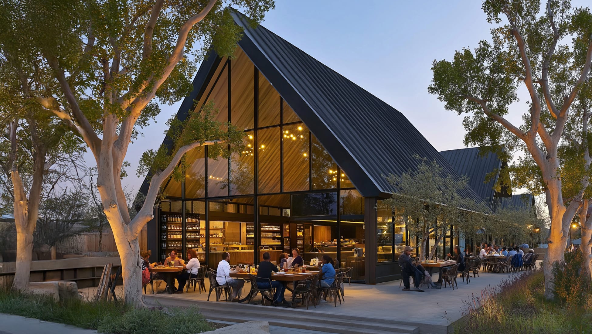 A-frame dining pavilion with warm lighting and outdoor patio seating at The Canopy at Great Park in Irvine - environmental graphic design and placemaking by RSM Design
