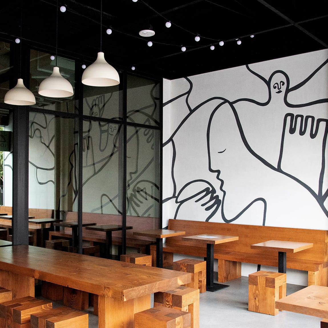 Restaurant interior at Runway Playa Vista featuring custom mural graphics and branded environmental design elements within the retail and dining district designed by RSM Design.