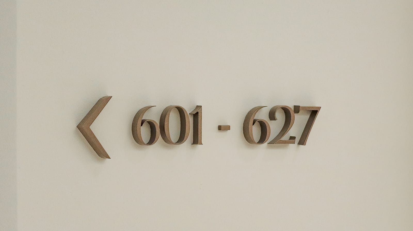 Dimensional directional sign reading "601 - 627" with custom Art Deco numerals at Maple Terrace - environmental graphic design by RSM Design