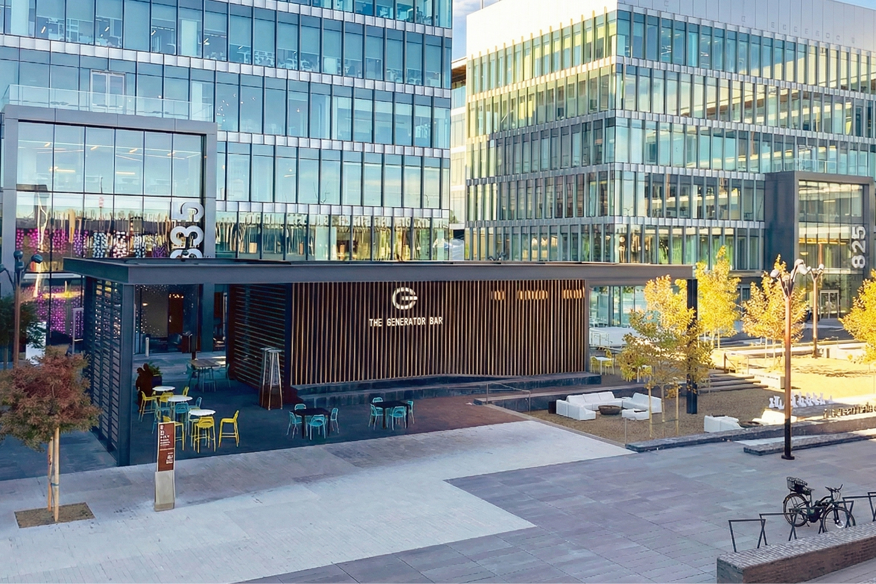 Exterior environmental branding and signage design for The Generator Bar at 825 San Carlos, featuring illuminated logo, wood slat facade, and outdoor patio by RSM Design