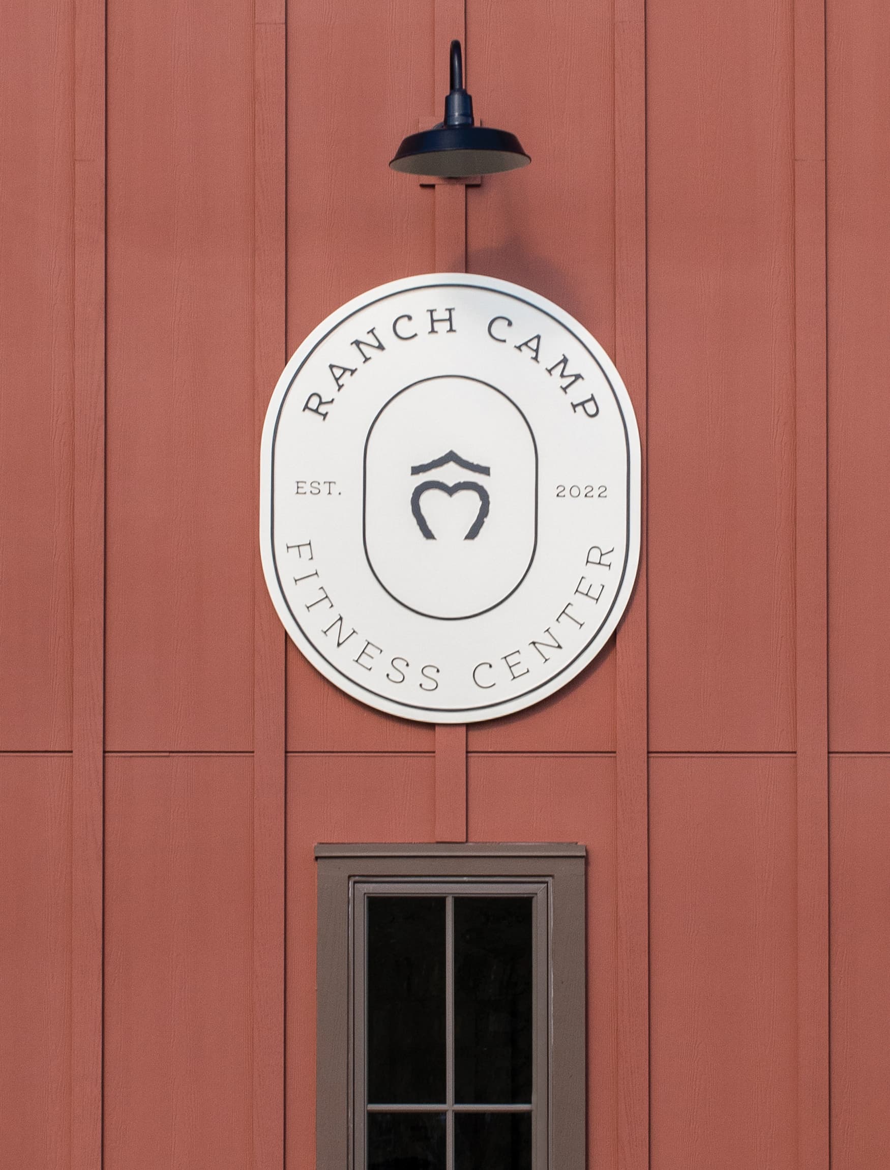 Close up detail of Ranch Camp Fitness Center and logo completed by RSM Design. Modern barn style typography and brand identity signage with clean font. 