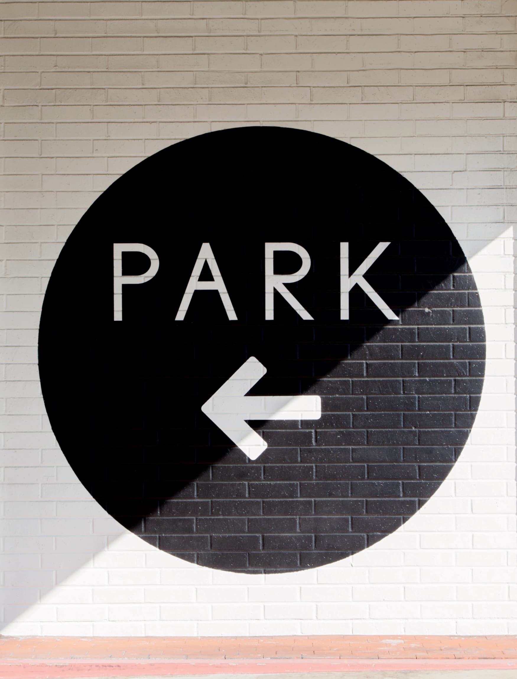 Image of the circular black painted wall graphic, labeled PARK. Wayfinding signage by RSM Design for Lido Marina Village. 