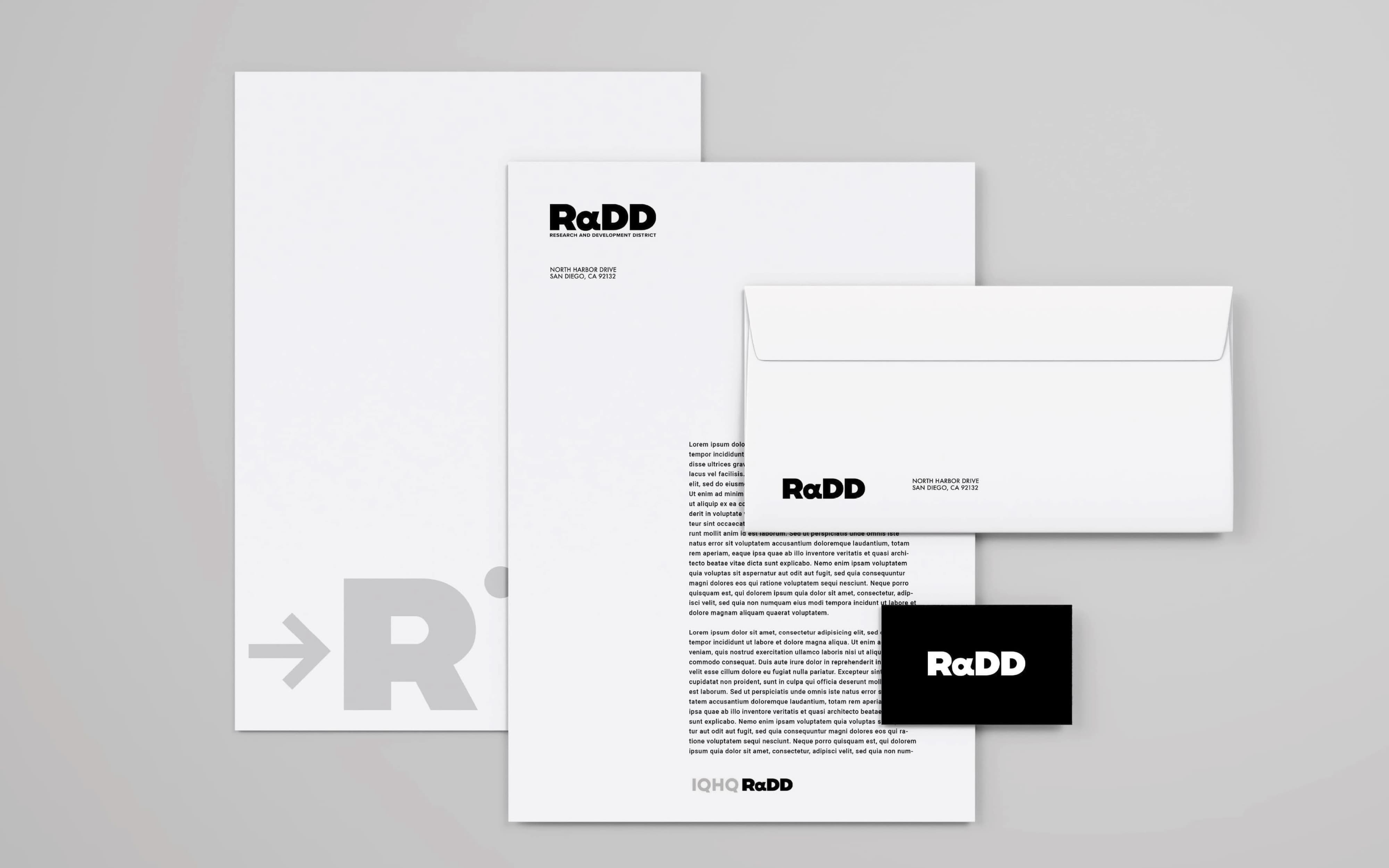 Stationery mockup for RαDD, Research and Development District, showing a letterhead with placeholder text, a matching envelope addressed to North Harbor Drive, San Diego, and a black business card, arranged on a light gray background.