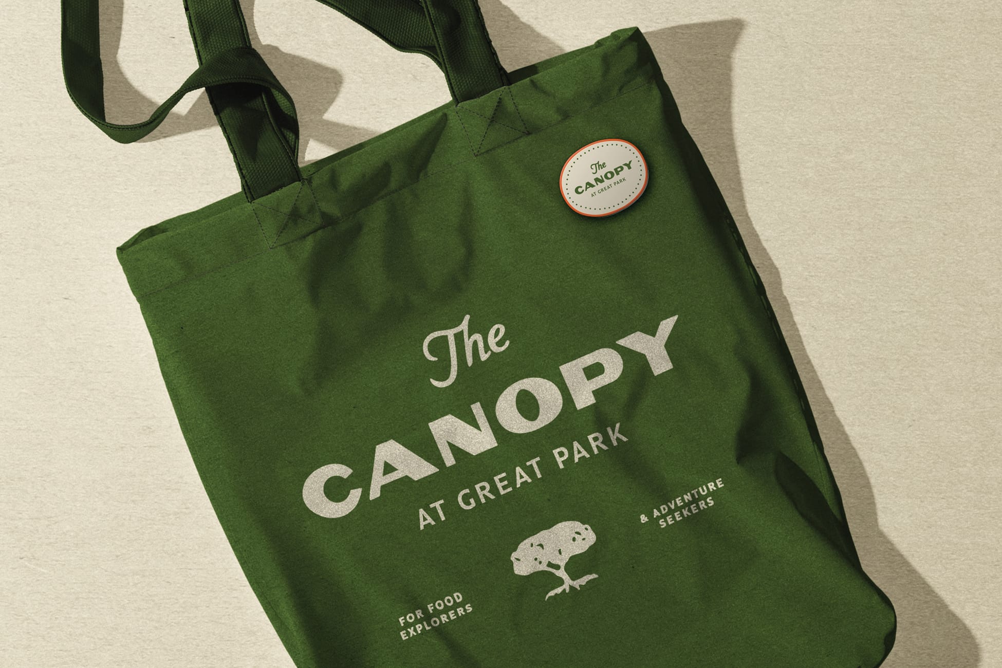 Green canvas tote bag with The Canopy at Great Park logo and pin - branded merchandise design by RSM Design