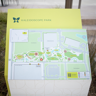 Kaleidoscope Park site map directory kiosk with lime green header, leaf logo, color-coded park map showing amenities, pathways, and points of interest, Frisco, Texas