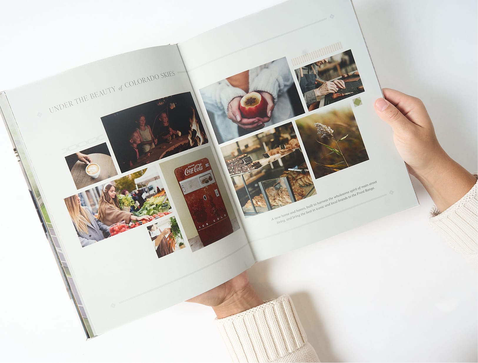 Hands holding open brand book spread titled "Under the Beauty of Colorado Skies" with market, bonfire, and bakery lifestyle photography, brand identity presentation book by RSM Design.