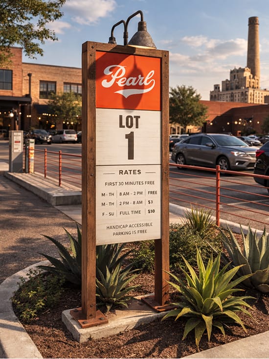 Pearl District parking signage for Lot 1 in San Antonio, featuring branded wayfinding design, clear rate information, and rustic materials integrated into the pedestrian streetscape and historic brewery setting.