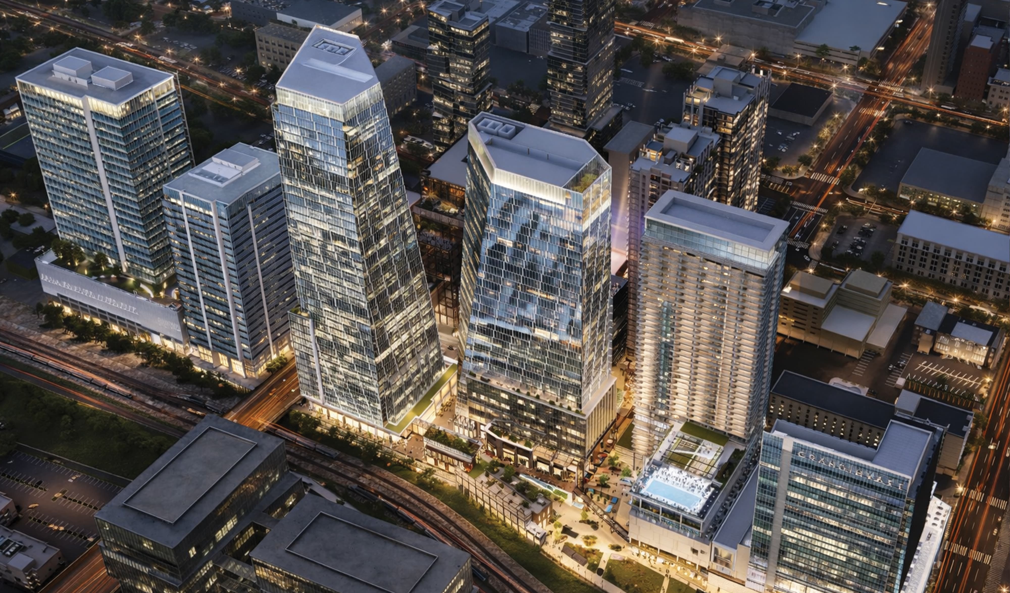 Aerial night rendering of the Nashville Yards mixed-use development featuring multiple high-rise office towers, the Grand Hyatt hotel, retail streetscape, and activated public plaza, illustrating the full scope of placemaking and master sign program design for a large-scale mixed-use and hospitality development by RSM Design.