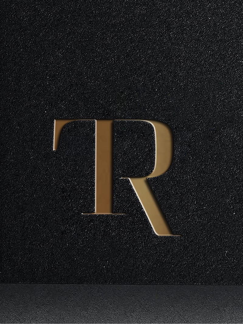 Brushed brass "TR" monogram letterform on textured black surface, Trick Rider, Omni PGA Frisco Resort, brand identity by RSM Design.